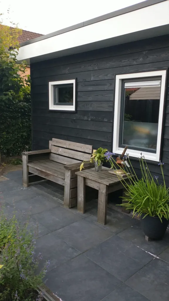 Garage met zwart Zweeds rabat en witte ramen